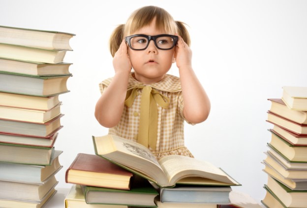 Ребенок в очках перед книгами